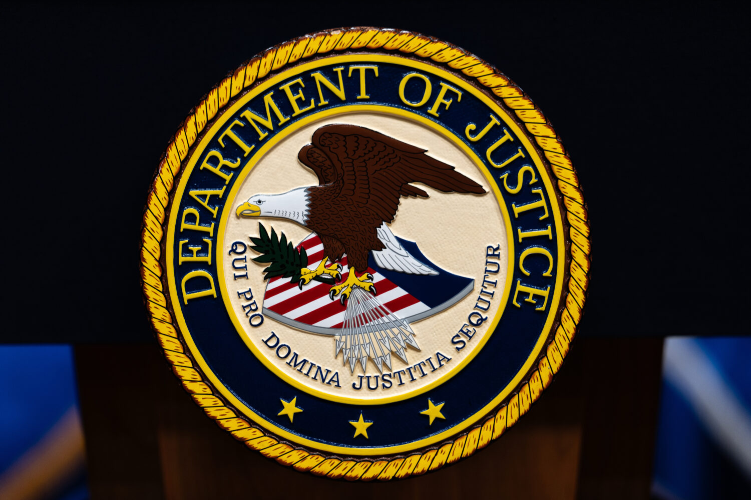 FILE - The U.S. Department of Justice logo is seen on a podium before a news conference, May 4, 202...