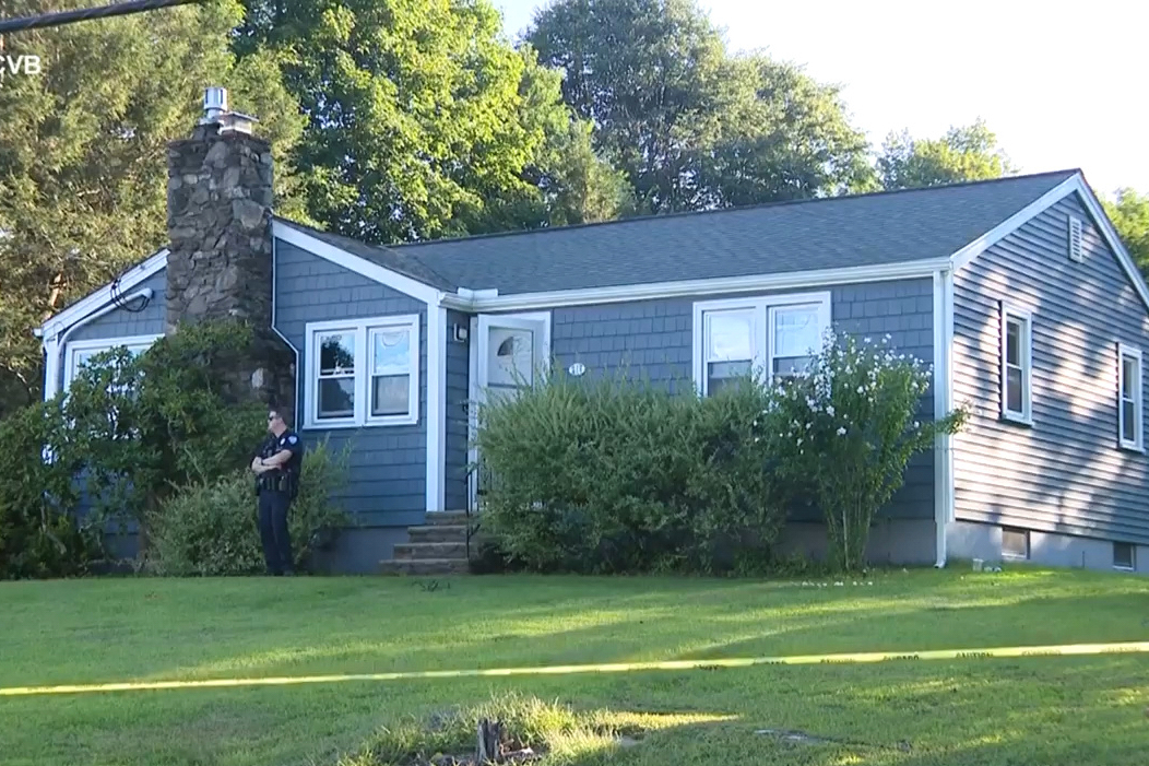 This screen grab made from video provided by WCVB-TV shows a police officer standing guard over a h...