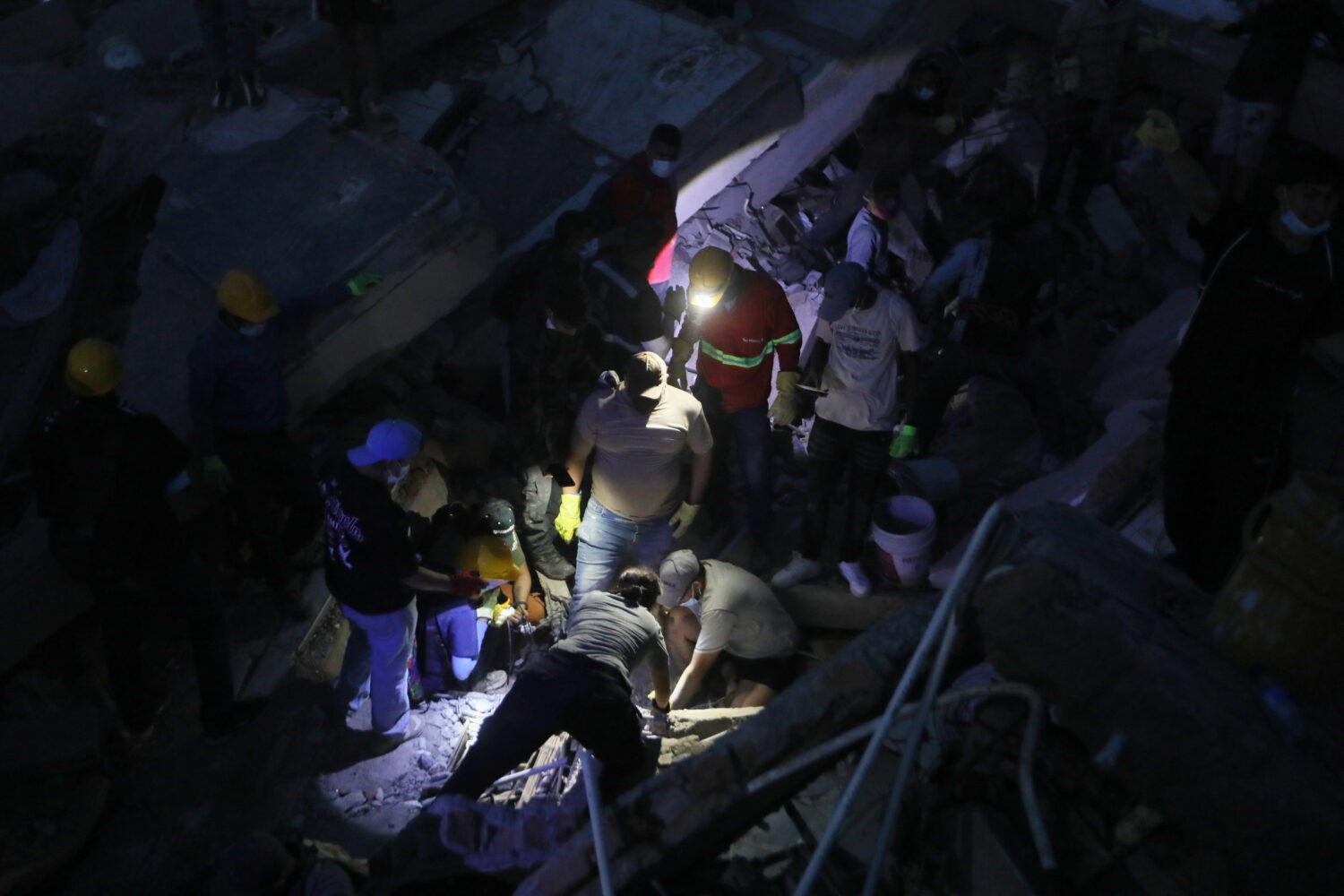People search through the rubble after an earthquake struck Cali, Colombia, Monday, Aug. 10, 2026. ...