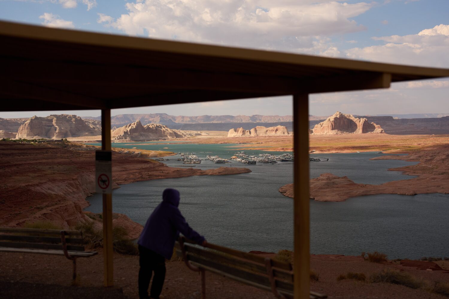 FILE - A person stands at an overlook near the Wahweap Marina on Lake Powell at the Glen Canyon Nat...