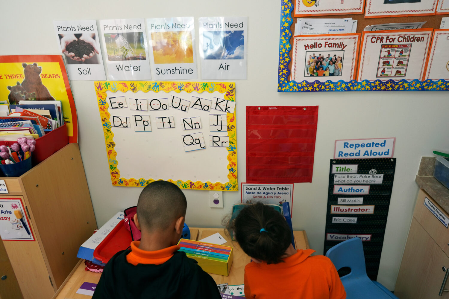 FILE - Students help put away supplies at the end of a reading and writing lesson at the Head Start...