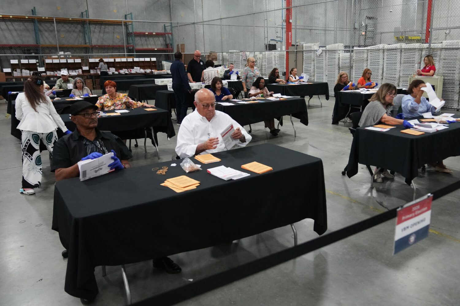 Election workers sort vote-by-mail ballots at the Miami-Dade County Supervisor of Elections Office ...