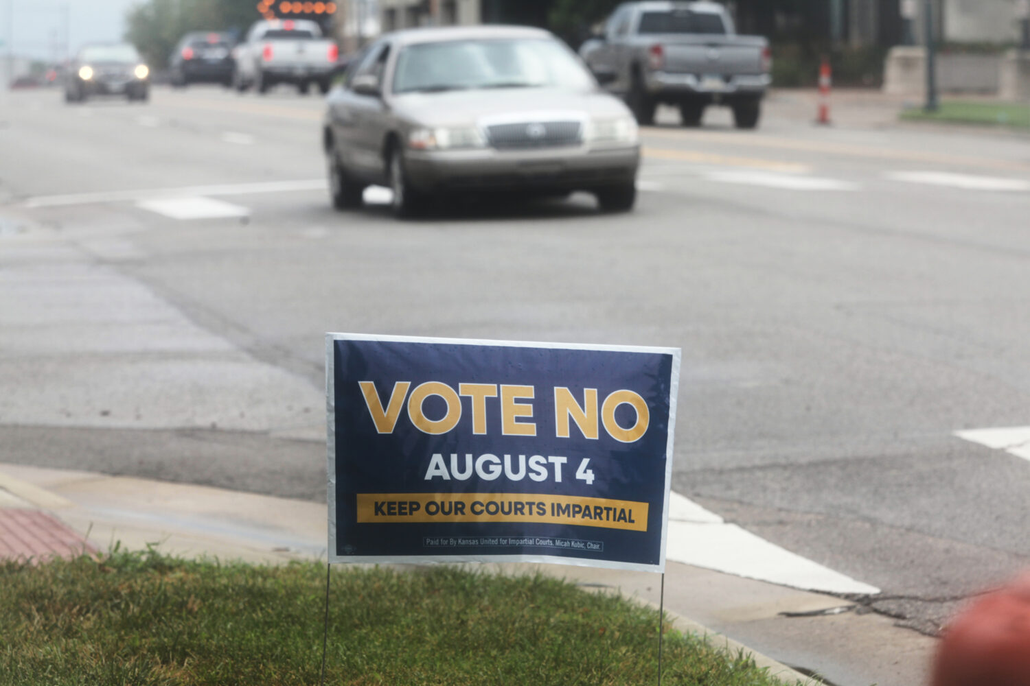 A sign encourages voters to reject a proposal to change how Kanas Supreme Court justices are seated...