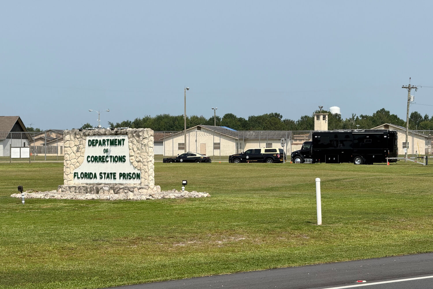 FILE - Law enforcement vehicles sit parked outside the Florida state prison in Starke, Fla., on Tue...