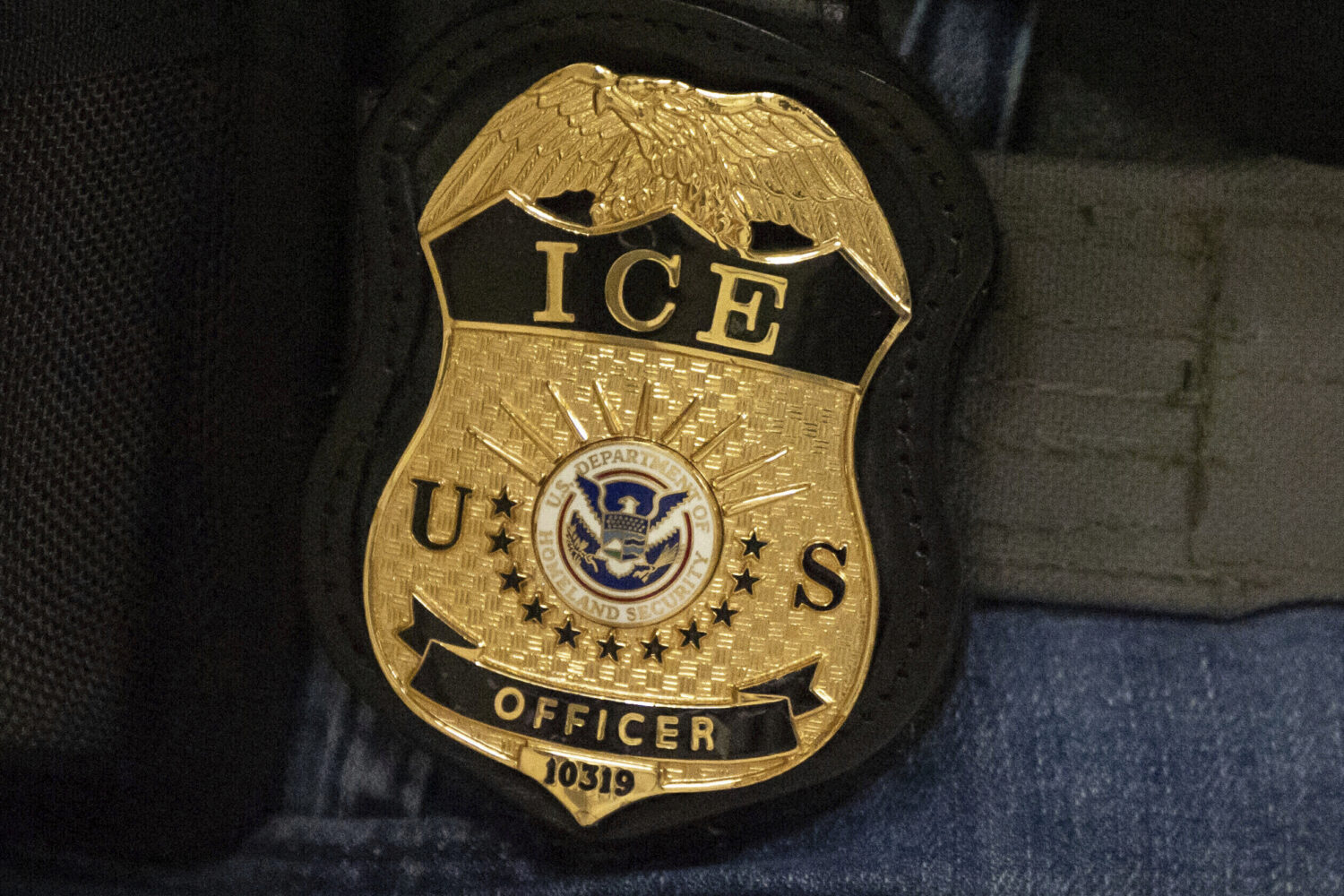 FILE - A federal agent wears an Immigration and Customs Enforcement badge in New York, June 10, 202...