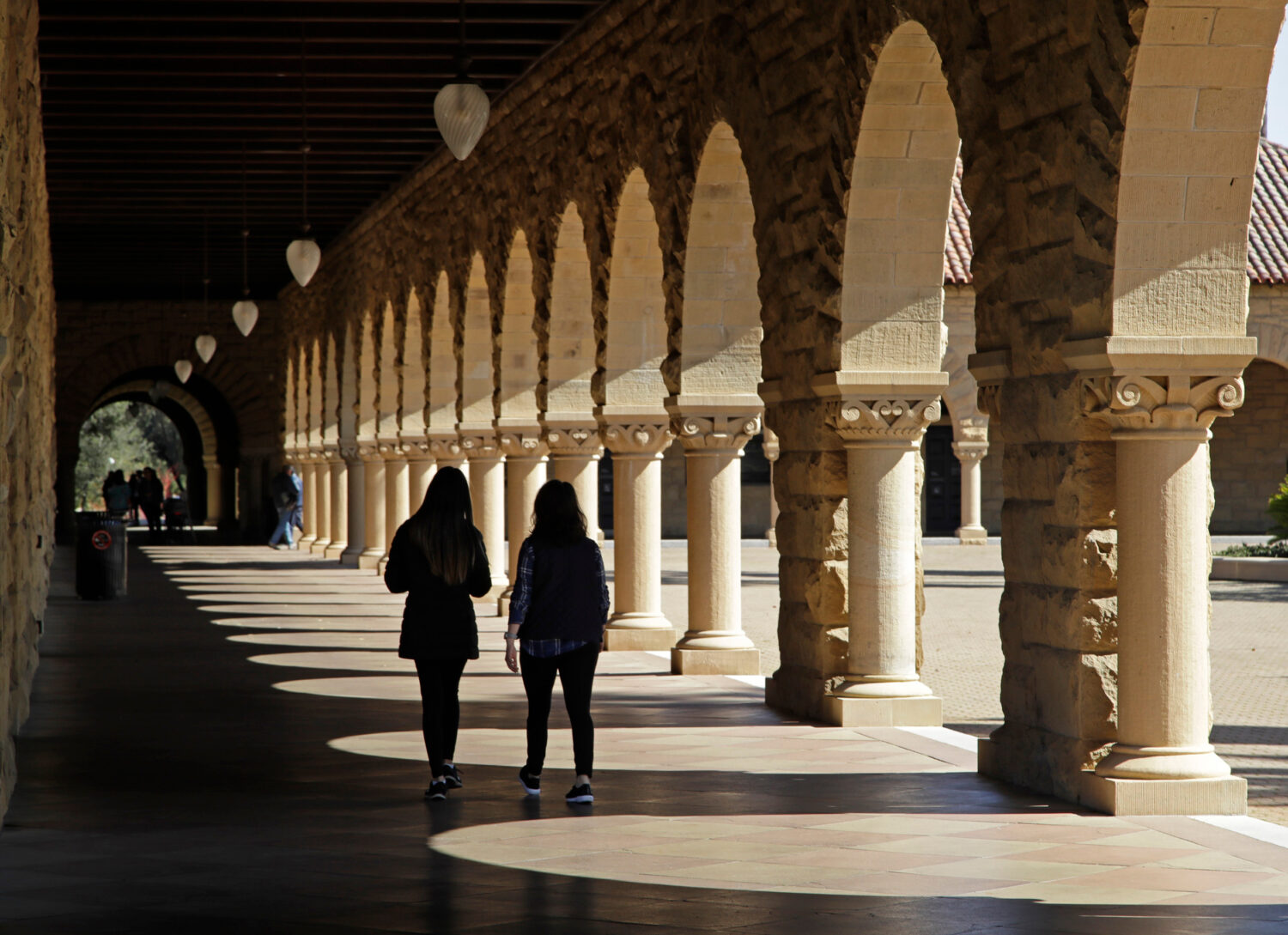 FILE - Students walk through the Stanford University campus, March 14, 2019, in Santa Clara, Calif....