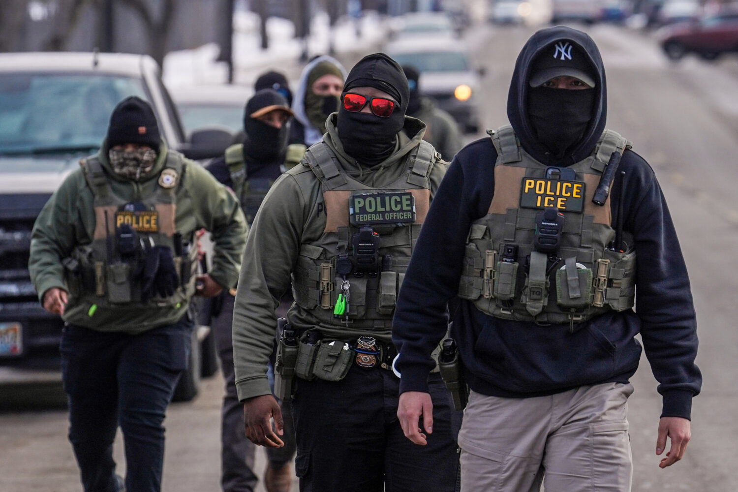 FILE - Federal agents walk down a street while conducting immigration enforcement operations in Min...