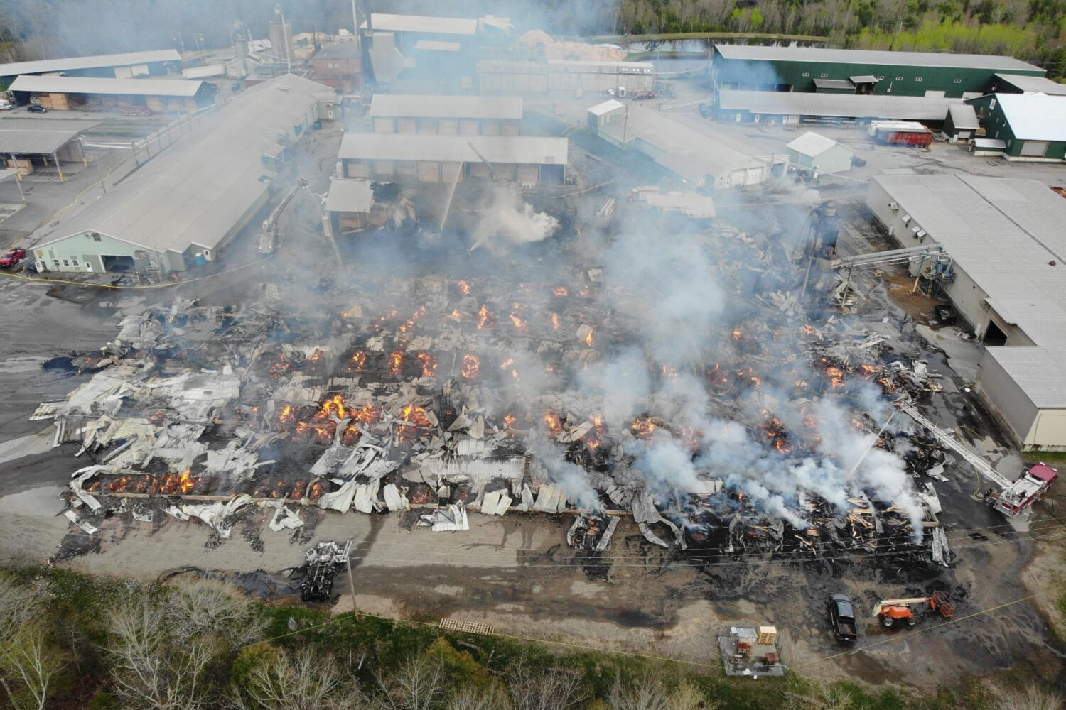 In this photo provided by the Maine State Fire Marshal, flames burn through Robbins Lumber followin...