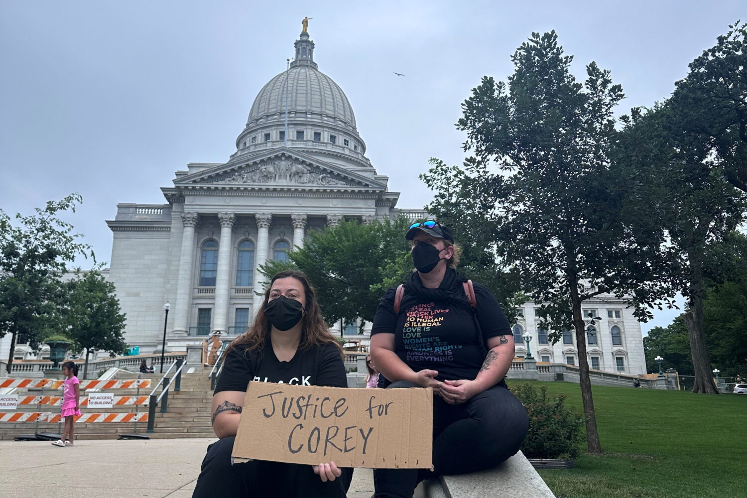 Lilly Nimmer, left, and Reba Bergmann, right, hold a sign to protest the police shooting of Corey R...
