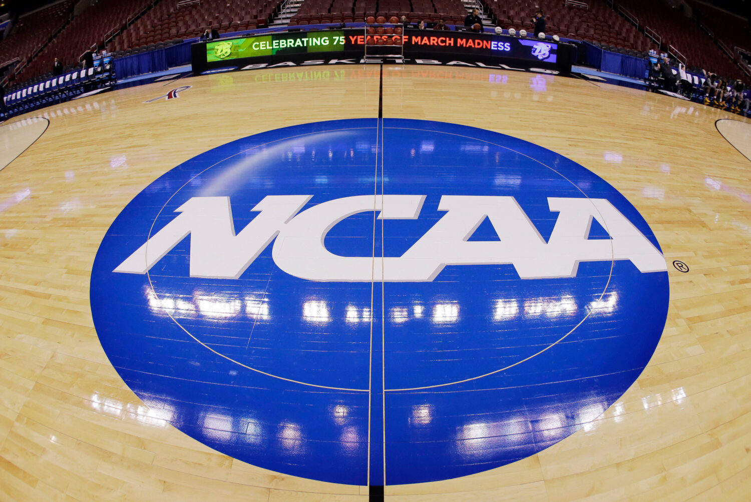 FILE - This photo taken with a fisheye lens shows the NCAA logo displayed at mid-court in Philadelp...