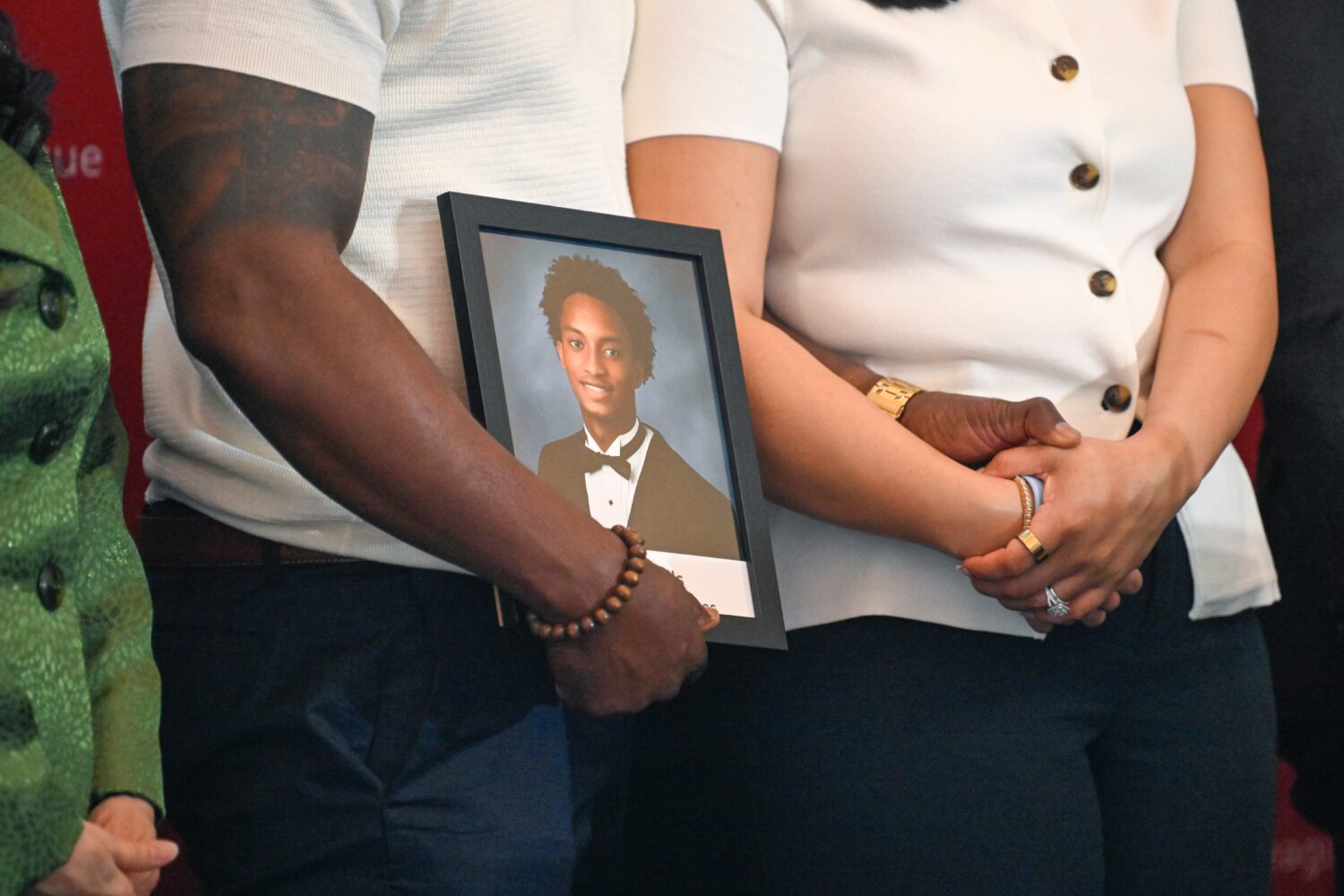 Christine Wonsley and Elmore Wonsley, mother and step father of Nolan Wells, stand on a stage with ...