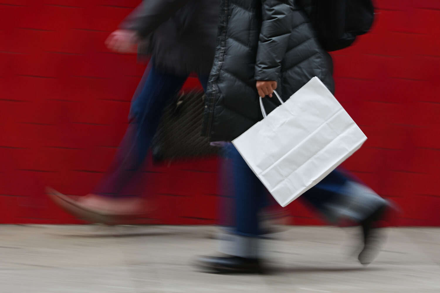 FILE - A person carries a shopping bag in Philadelphia, Dec. 10, 2025. (AP Photo/Matt Rourke, File)...