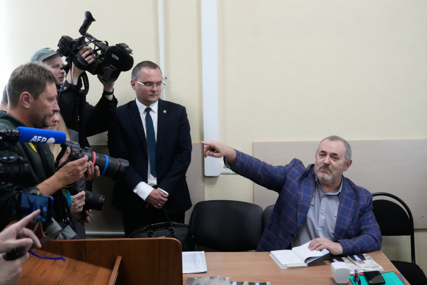 Russian politician Boris Nadezhdin, right, accused of displaying "extremist symbols," gestures spea...