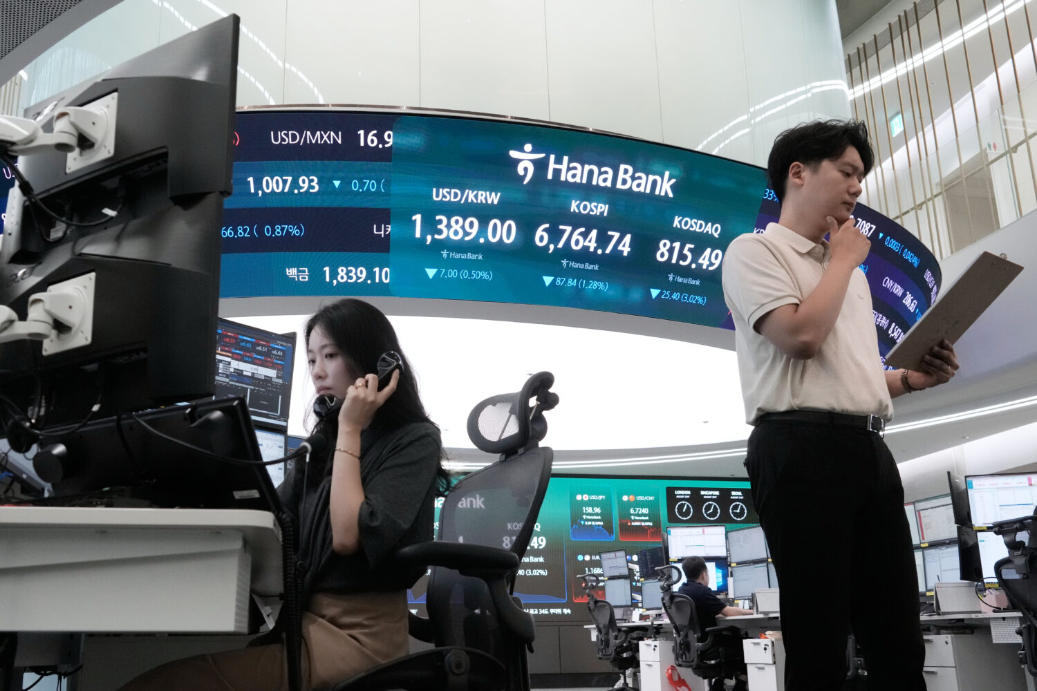Currency traders work at the foreign exchange dealing room of the Hana Bank headquarters in Seoul, ...