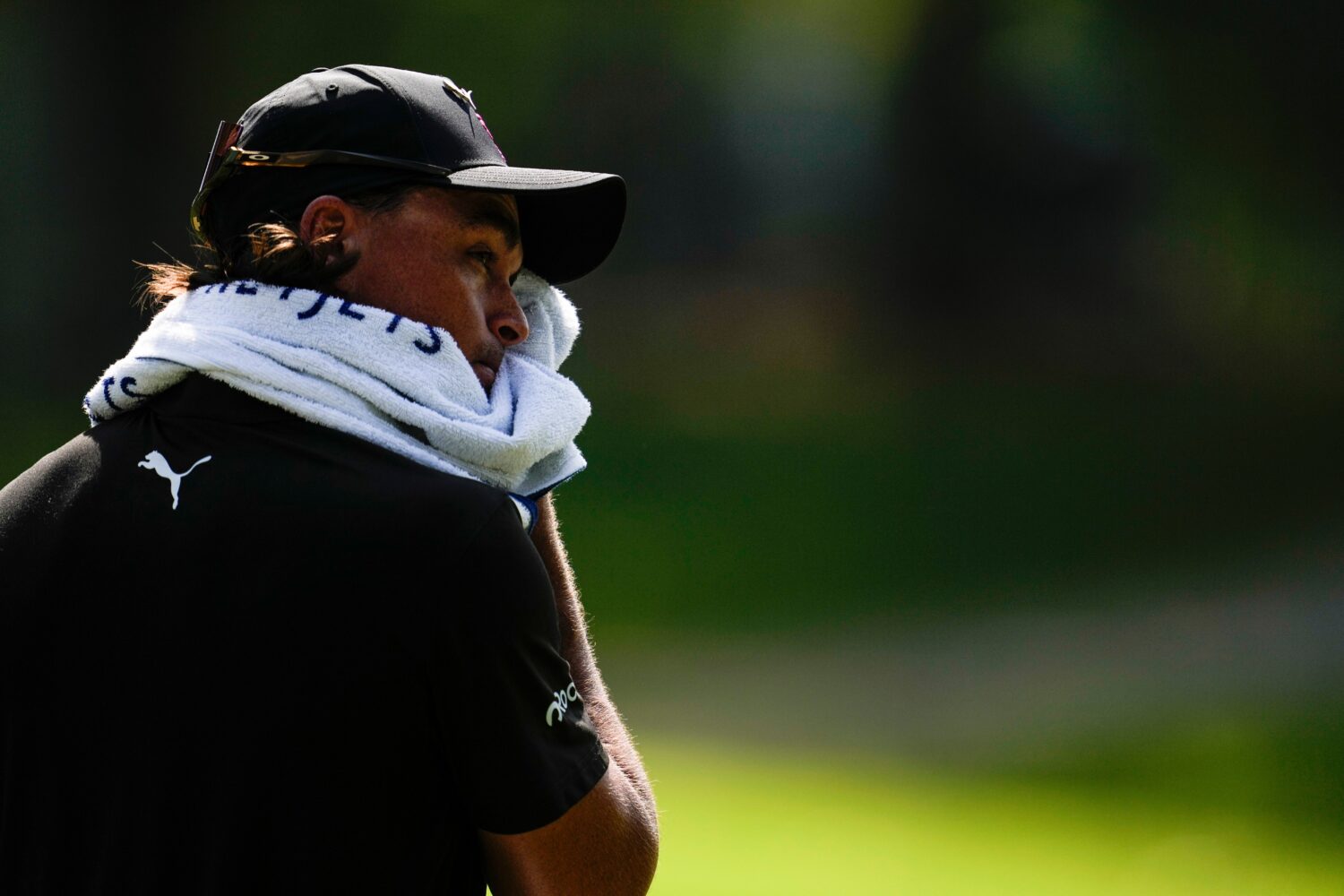 Rickie Fowler wipes his face in the heat off the fifth tee box during the first round of the St. Ju...