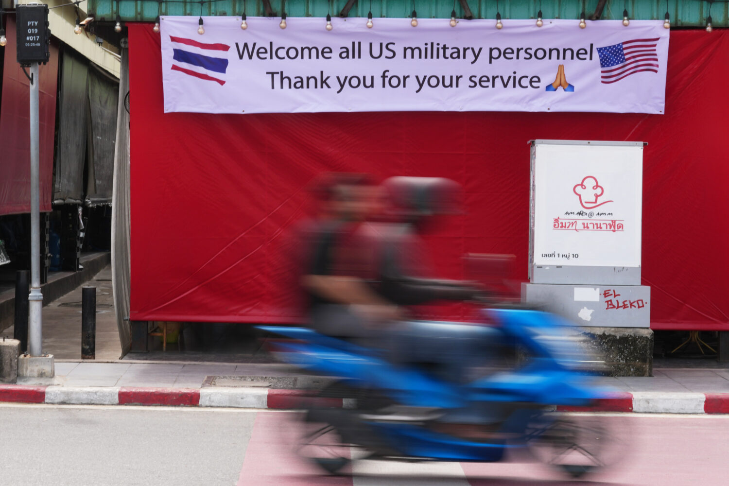 A motorcycle taxi drives past a banner in Pattaya, Thailand, Tuesday, Sept. 1, 2026. (AP Photo/Sakc...