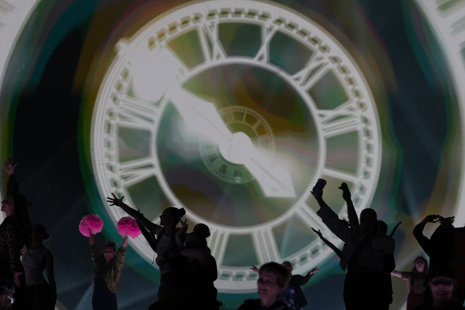 FILE - Performers celebrate the Glasgow Central railway station clock during the Commonwealth Games...