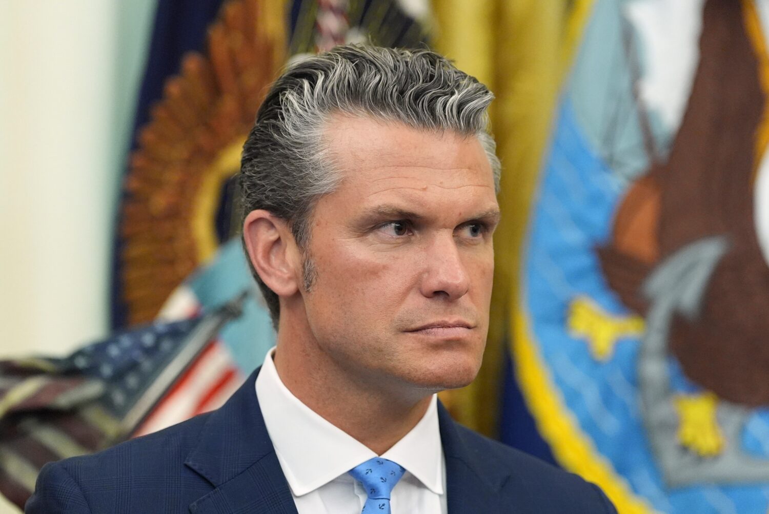 Defense Secretary Pete Hegseth listens as President Donald Trump speaks during a meeting about mili...