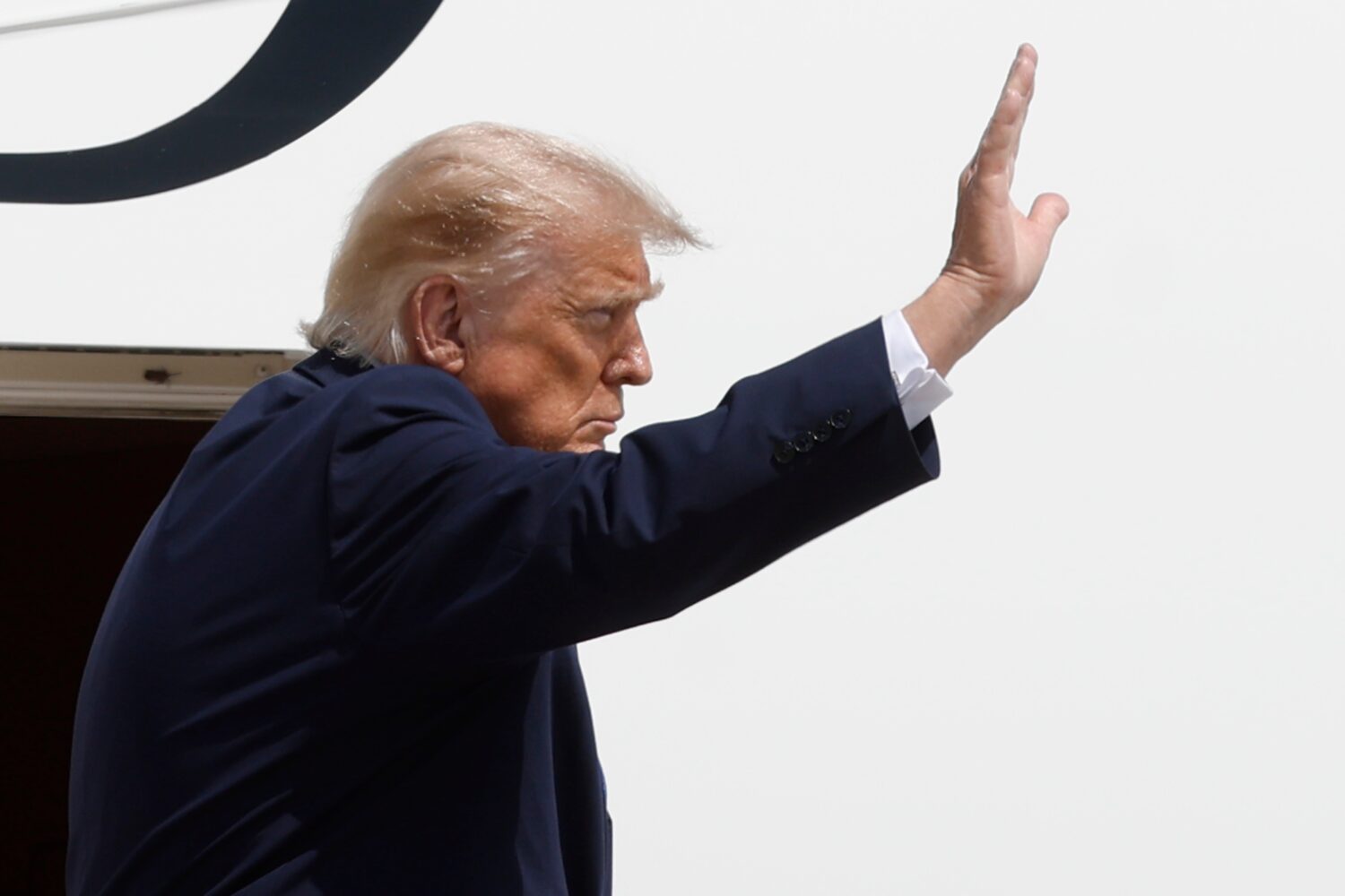 President Donald Trump waves from the stairs of Air Force One at Joint Base Andrews, Md., Tuesday, ...