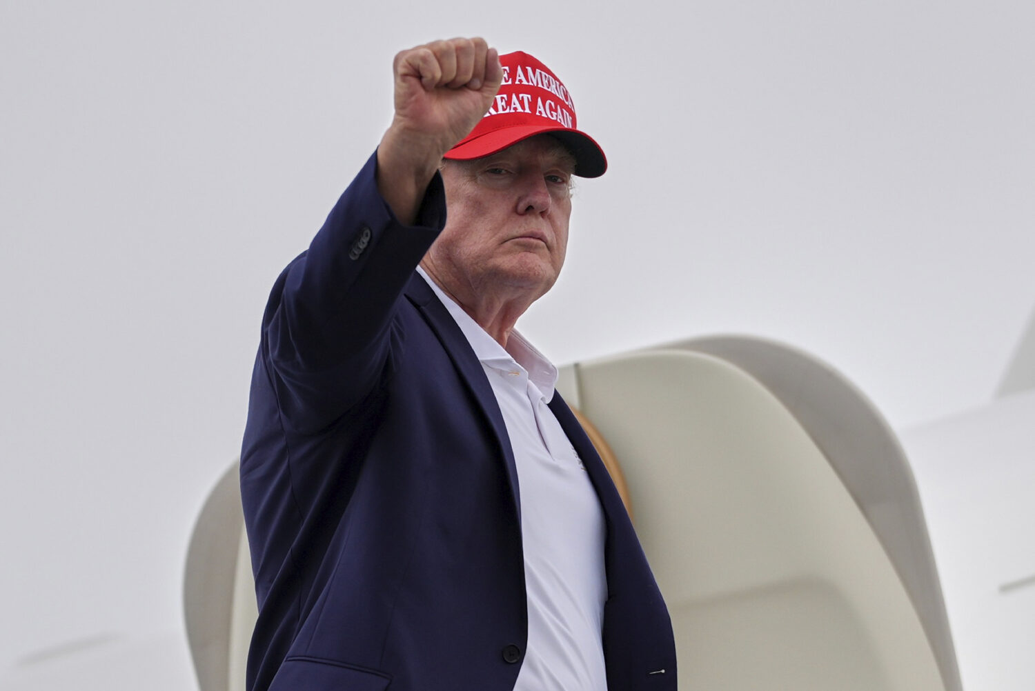 President Donald Trump gestures as he boards Air Force One at Morristown Airport, Sunday, Aug. 16, ...