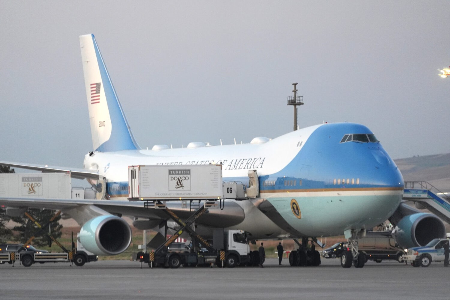 Catering trucks are parked at Air Force One on the tarmac as the motorcade carrying U.S. President ...