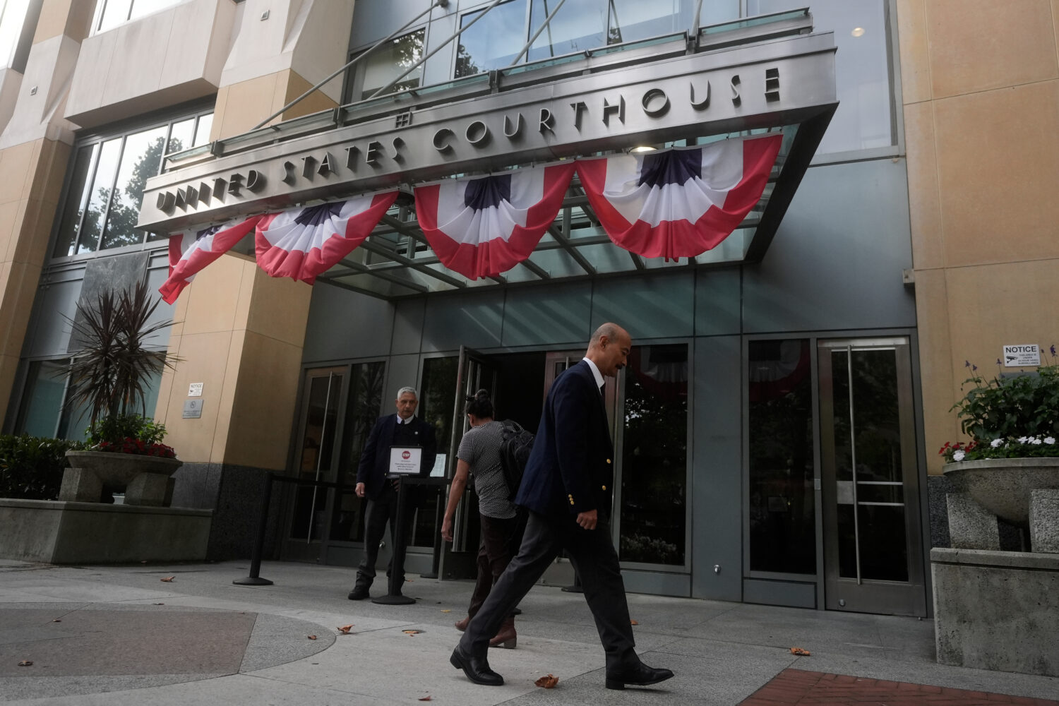 People walk outside of a Federal Courthouse Wednesday, Aug. 12, 2026, in Oakland, Calif. (AP Photo/...