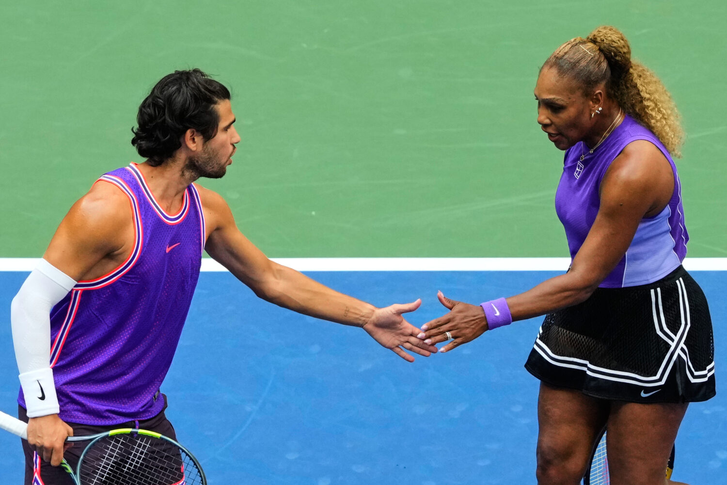 Carlos Alcaraz, of Spain, left, and Serena Williams, of the United States, high-five during a mixed...