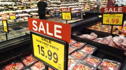 People shop near 'Sale' signs in the meats section of a grocery store. (Photo: Mario Tama, Getty Im...