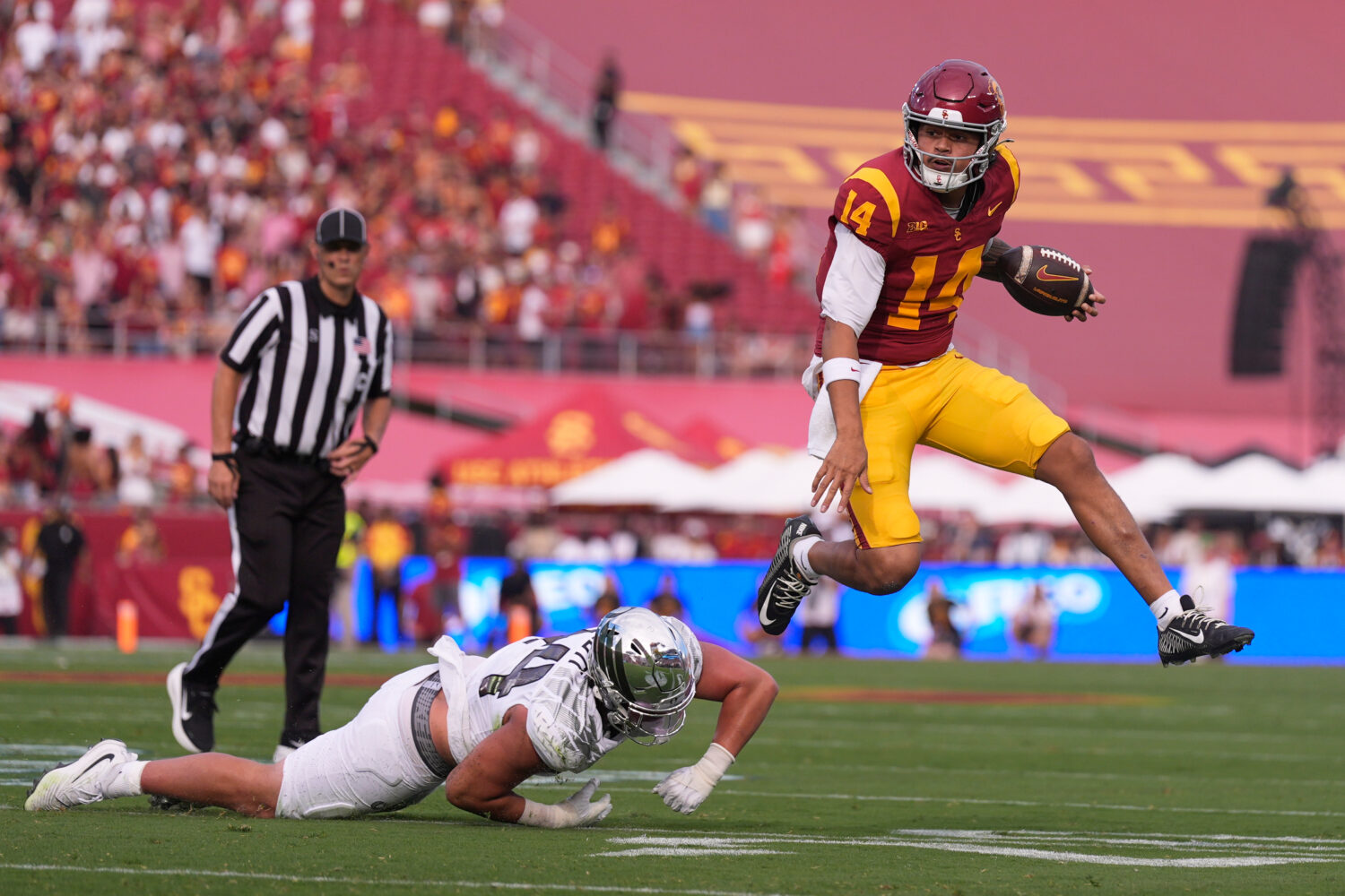 Southern California quarterback Jayden Maiava, right, jumps away from Oregon linebacker Teitum Tuio...