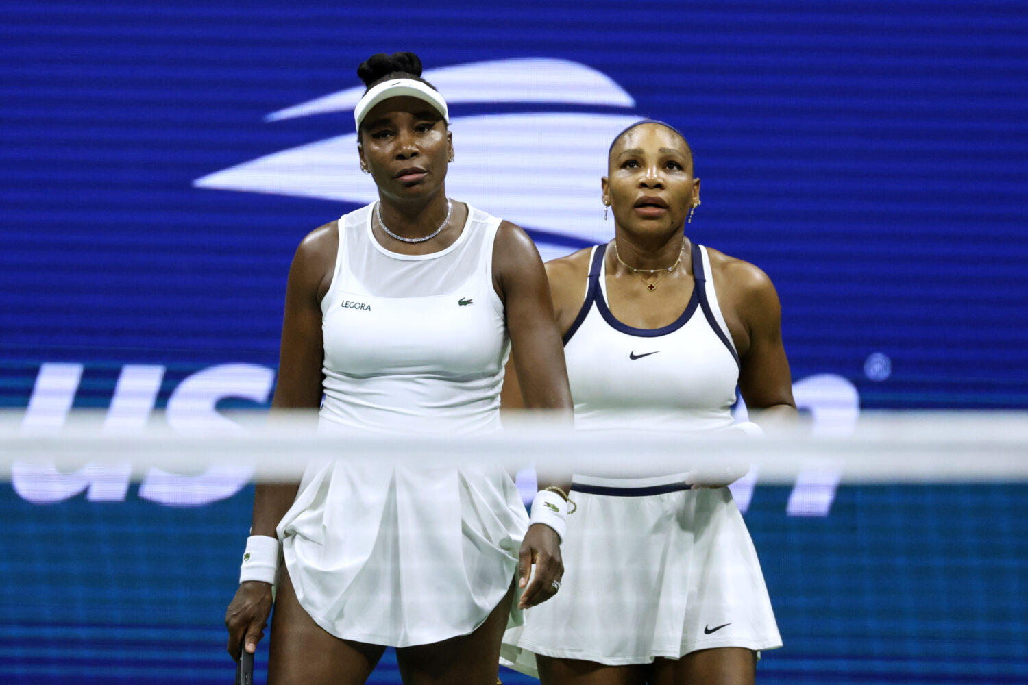 Venus Williams, left, and Serena Williams, of the United States, look on as they play against Hao-C...