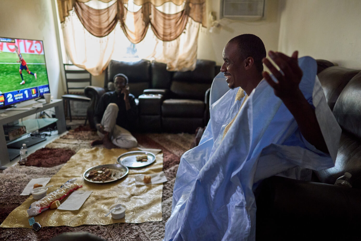 Samba Diallo, right, wears his daraa, a traditional robe worn in his homeland, Mauritania, after ea...