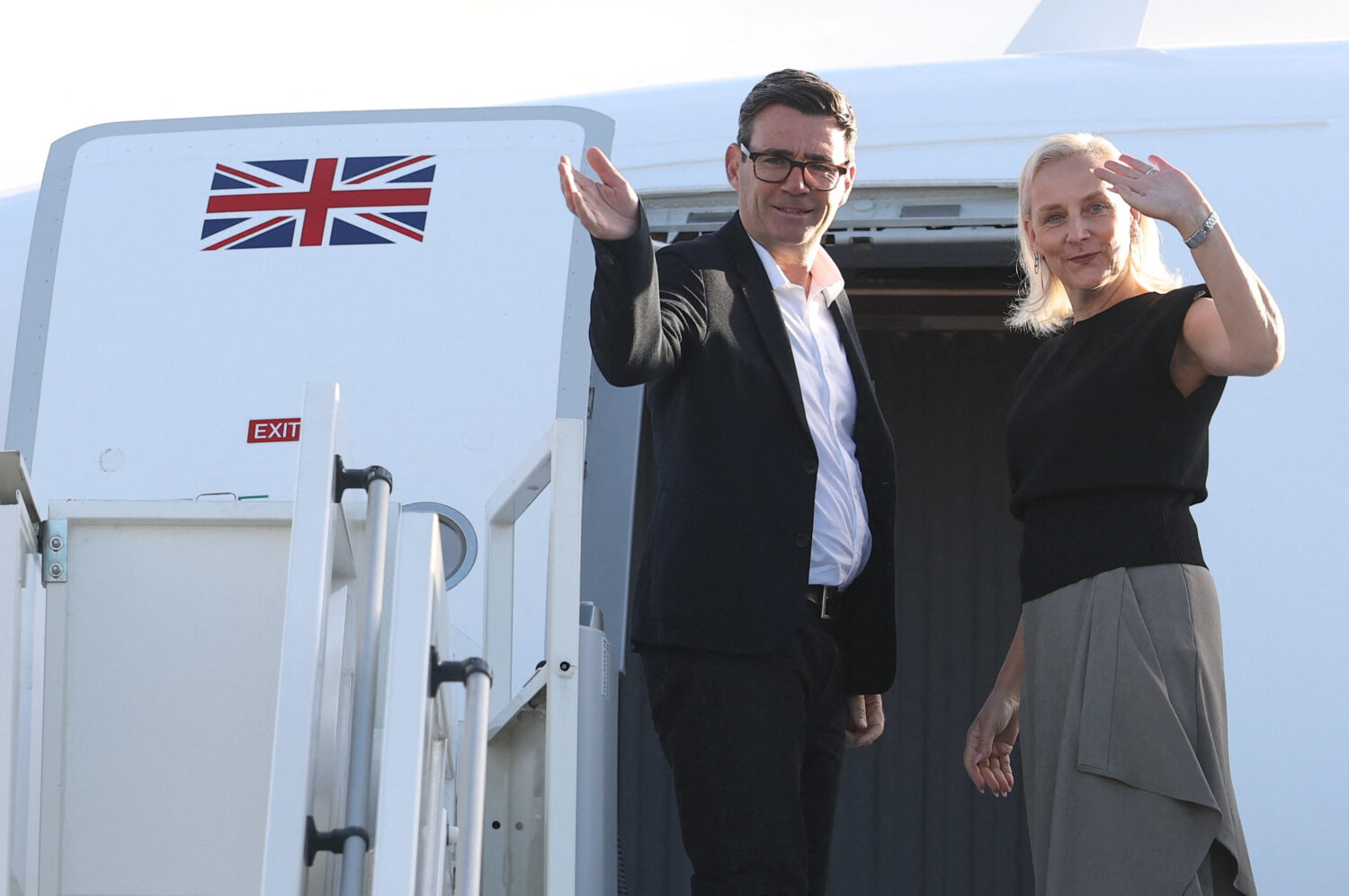Britain's Prime Minister Andy Burnham and his wife Marie-France van Heel board a plane for the Unit...