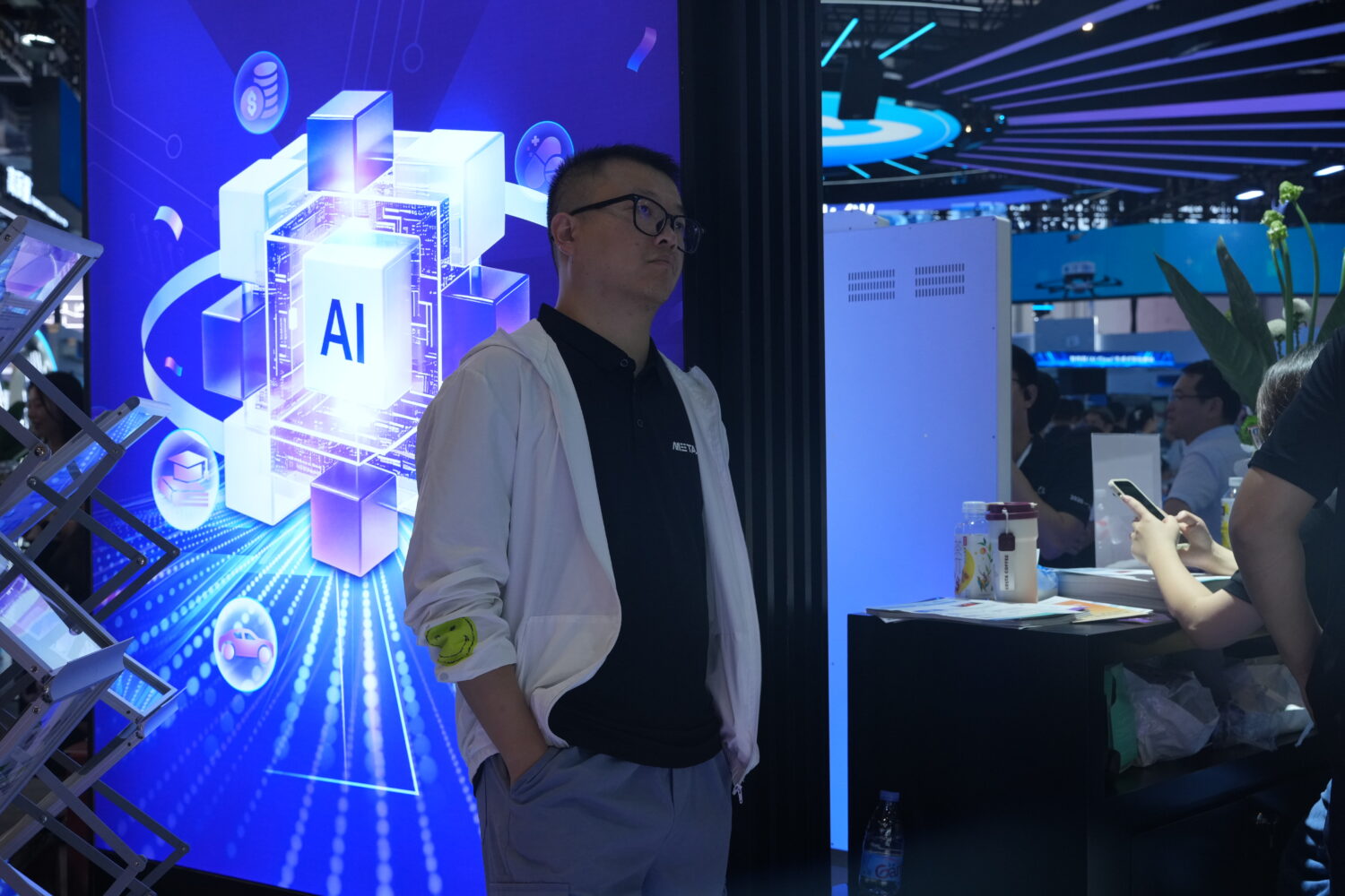 A visitor stands near a display about AI during the World AI Conference in Shanghai, China on July ...