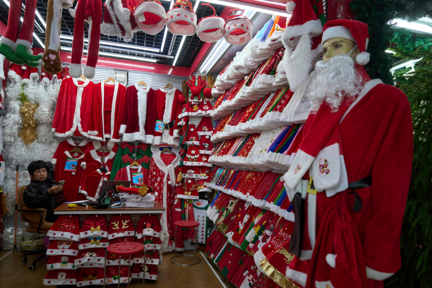 FILE - A vendor waits for customers near Santa costumes for sale at the Yiwu International Trade Ma...
