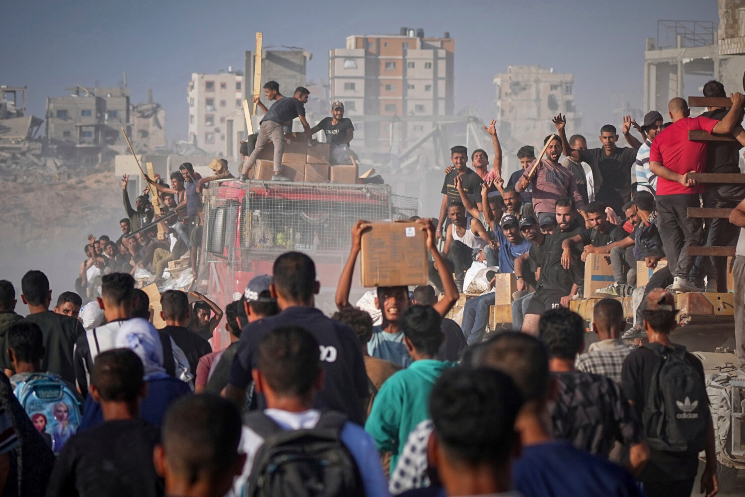 FILE -Palestinians ride on a truck loaded with food and humanitarian aid from the World Food Progra...