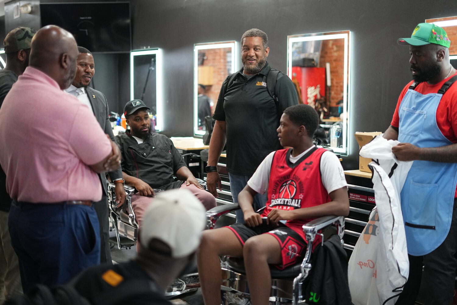Khalil Thompson, center, co-founder of Win With Black Men, leads a discussion at Philly Cuts barber...