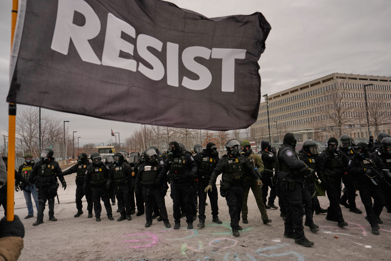 FILE - Federal immigration officers confront protesters outside Bishop Henry Whipple Federal Buildi...