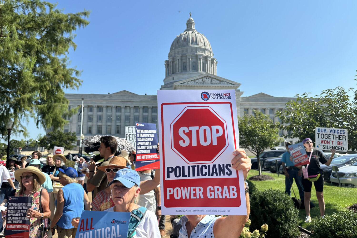 In this photo taken with a smartphone, people opposed to a congressional redistricting plan rally o...