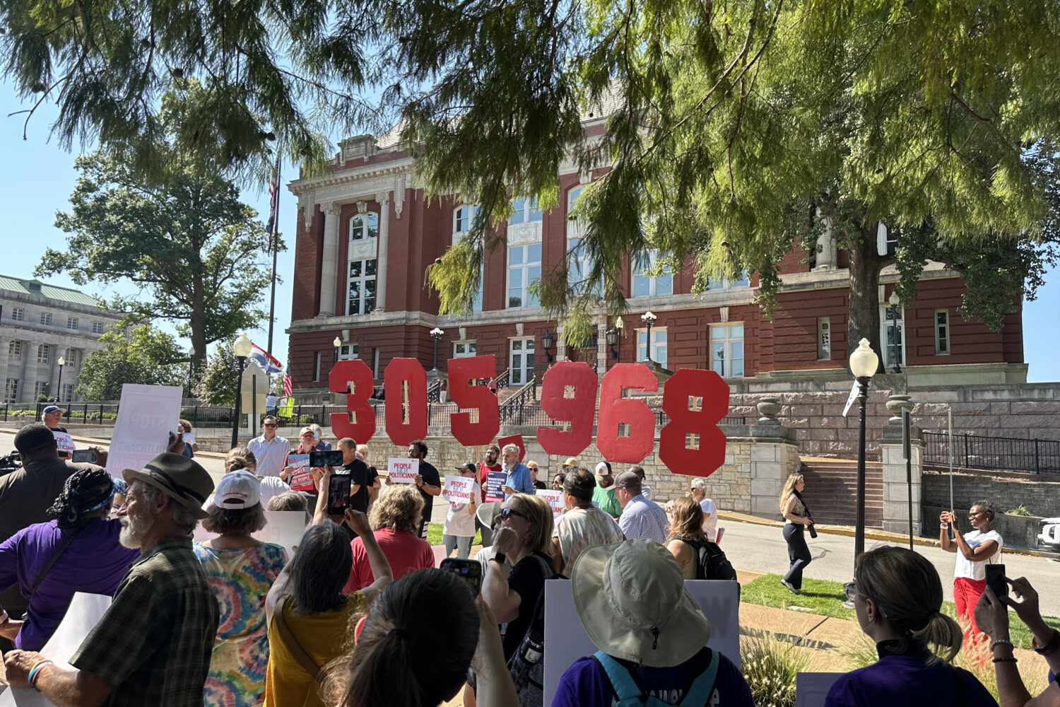 In this photo taken with a smartphone, people opposing a congressional redistricting plan rally out...