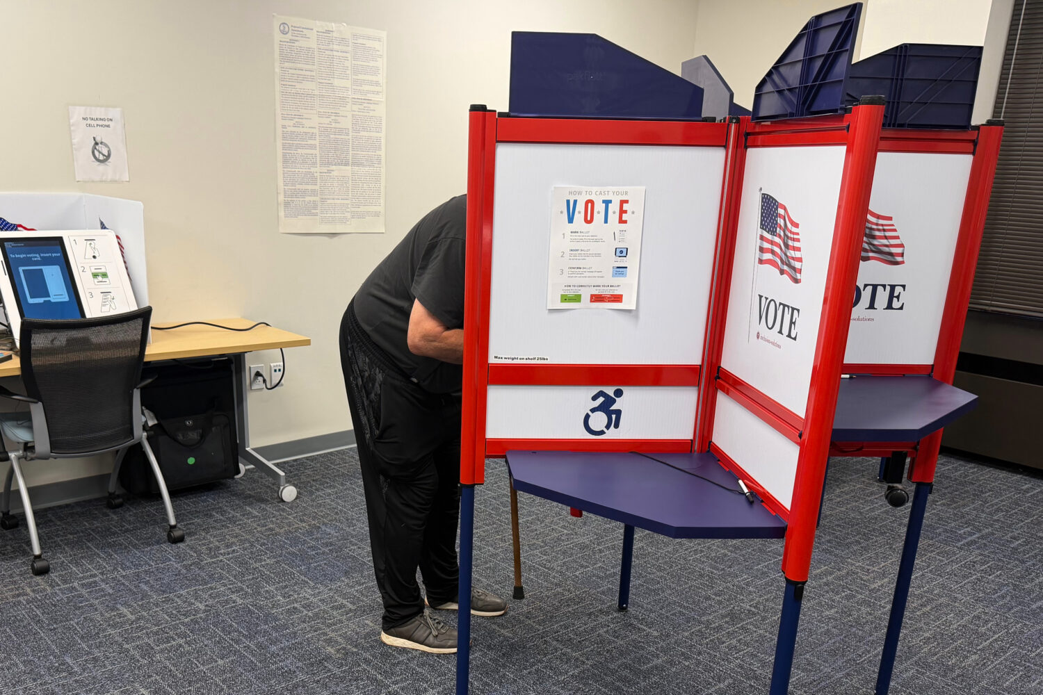 A voter casts a ballot in Henrico County, Va., on the first day of in-person early voting Friday, S...