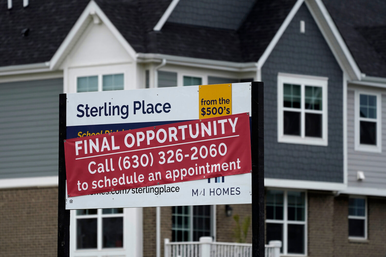 FILE - An advertising sign for building land stands in front of a new home construction site in Nor...