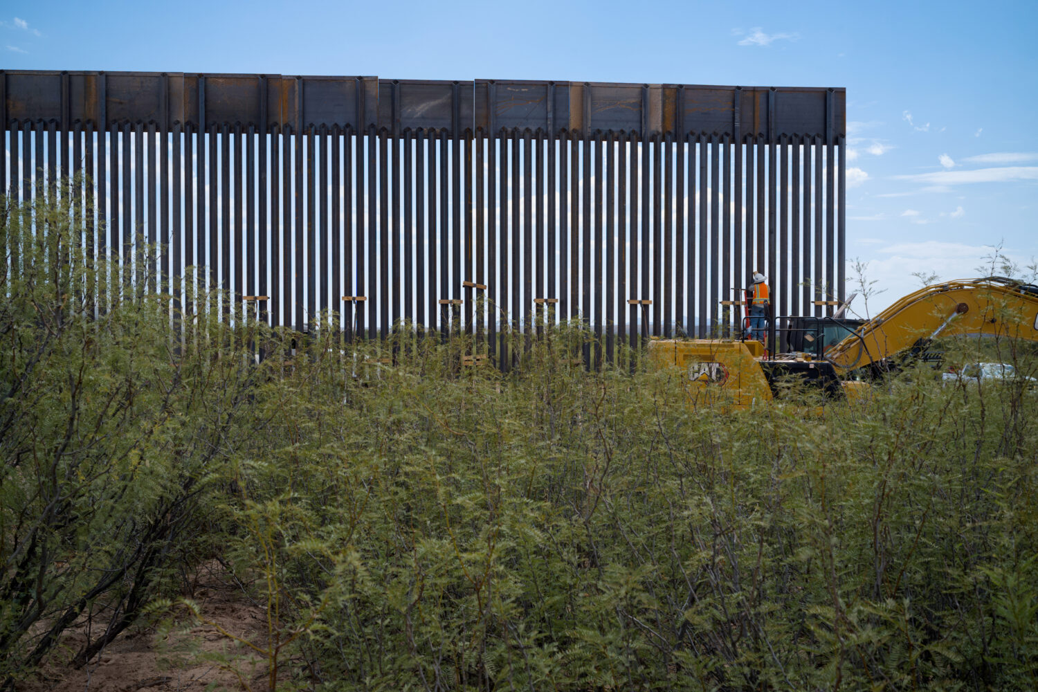 In this photo provided by Scott McWilliams, crews install the first sections of a new border wall i...