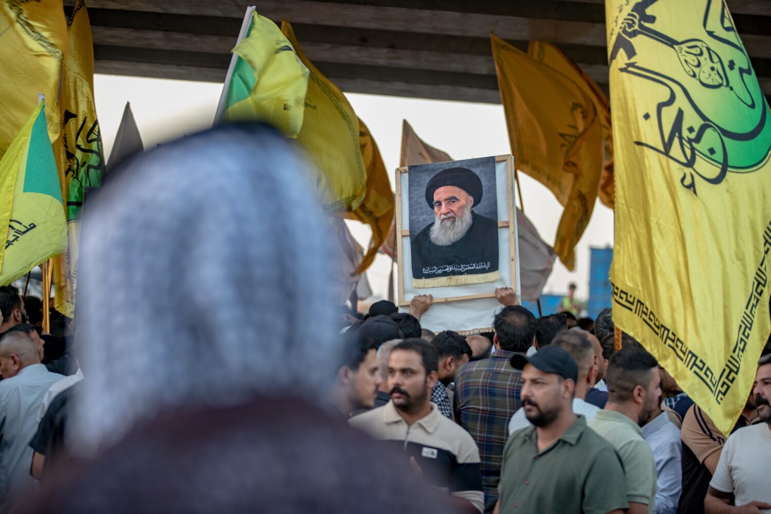 A demonstrator holds a portrait of Iraq's top Shiite cleric, Grand Ayatollah Ali al-Sistani, during...