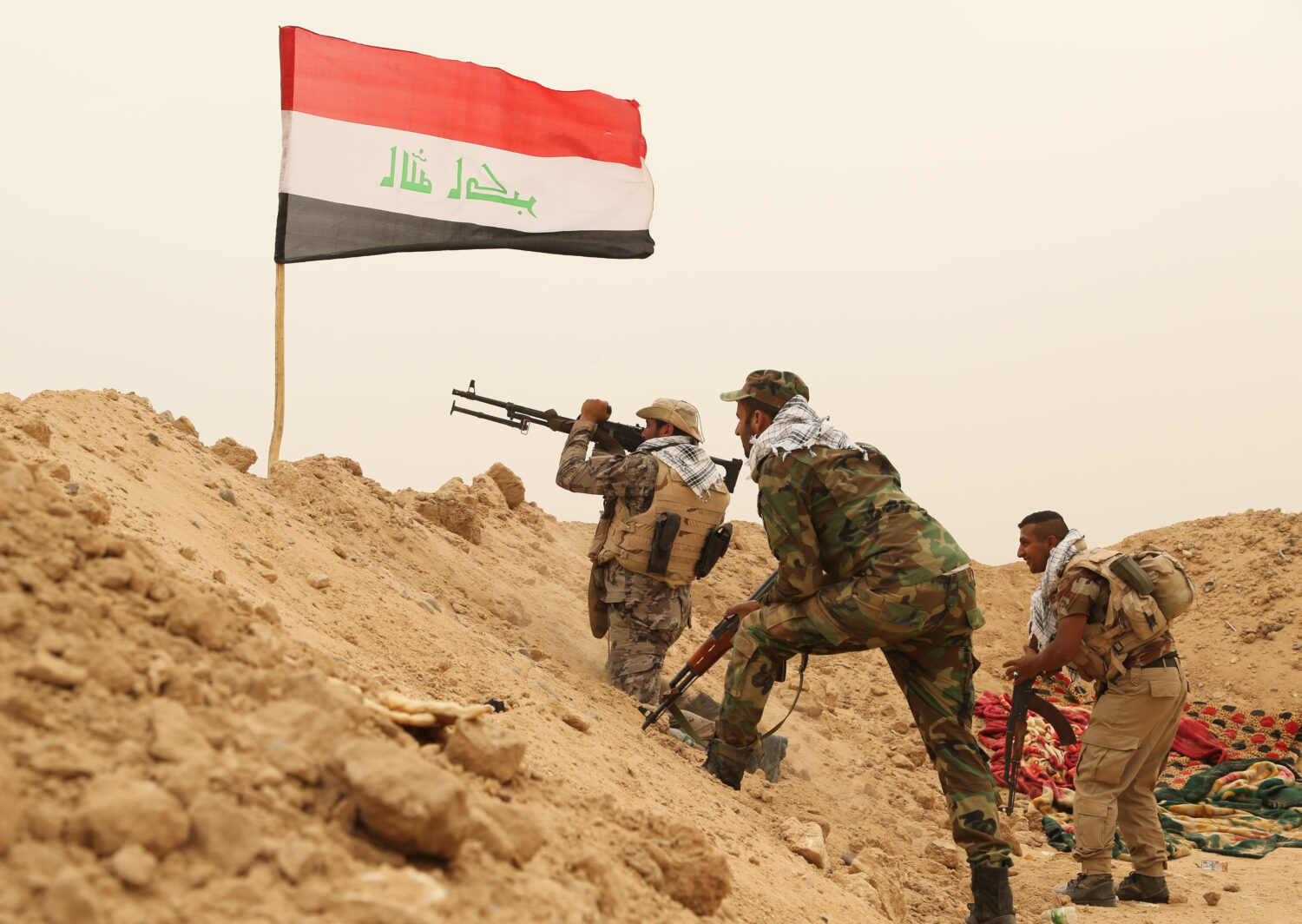 FILE - Fighters from the Badr Brigades Shiite militia clash with an Islamic State militant group at...