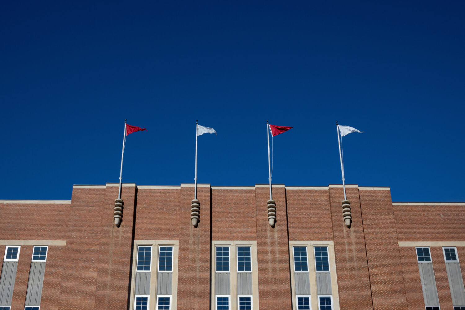 FILE - Flags fly at the Reynolds Coliseum at North Carolina State University Feb. 19, 2022, in Rale...