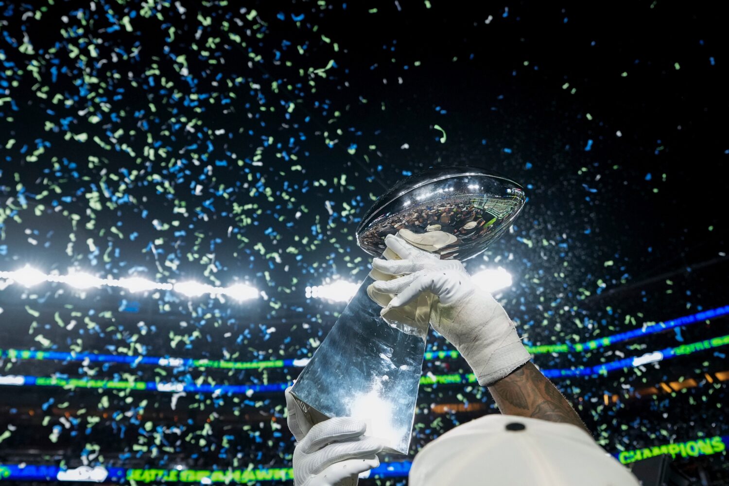 FILE - A member of the Seattle Seahawks celebrates with the Lombardi Trophy after defeating the New...