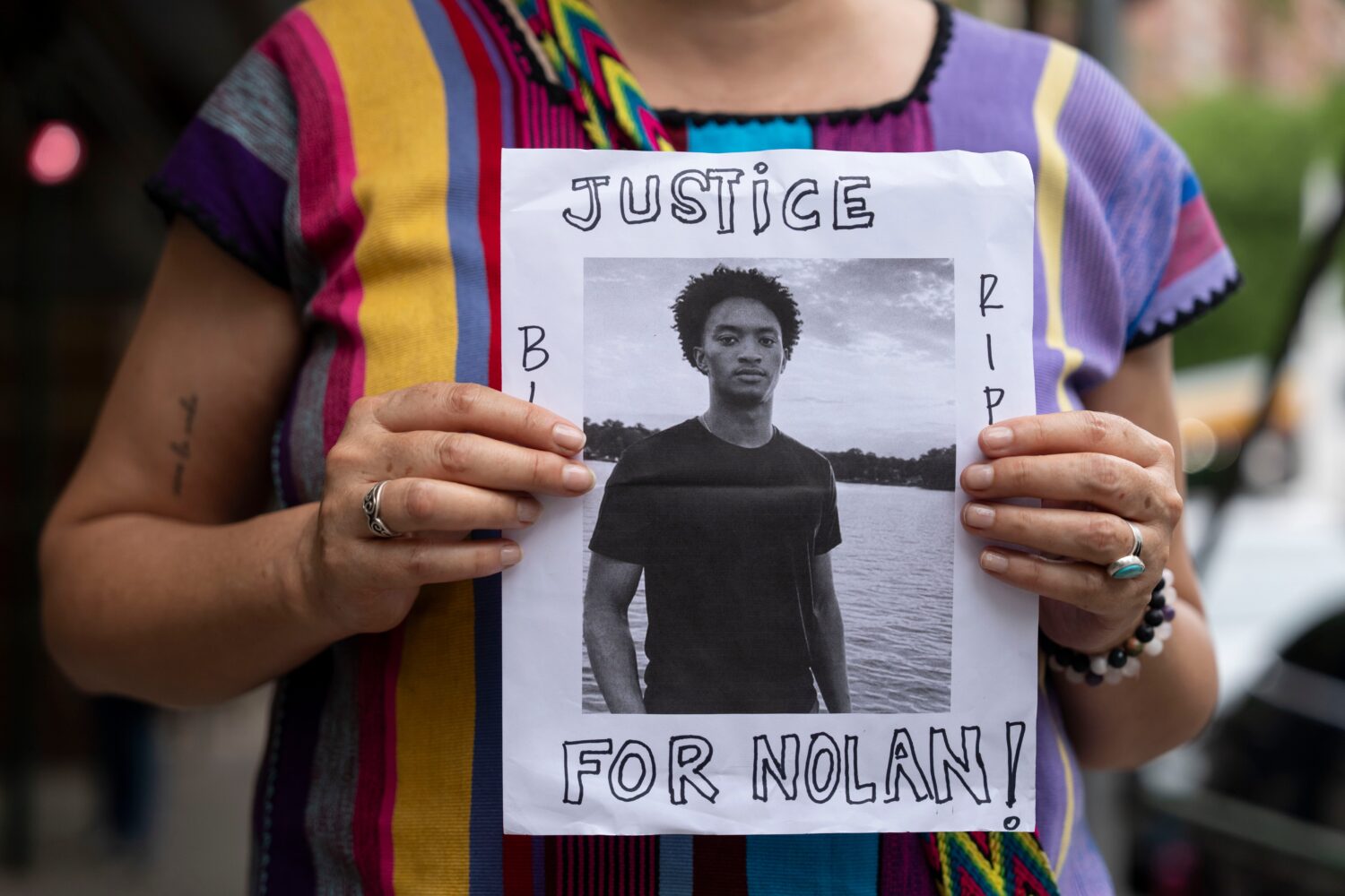 FILE - A person holds a picture of Nolan Xavier Wells during a news conference at National Action N...