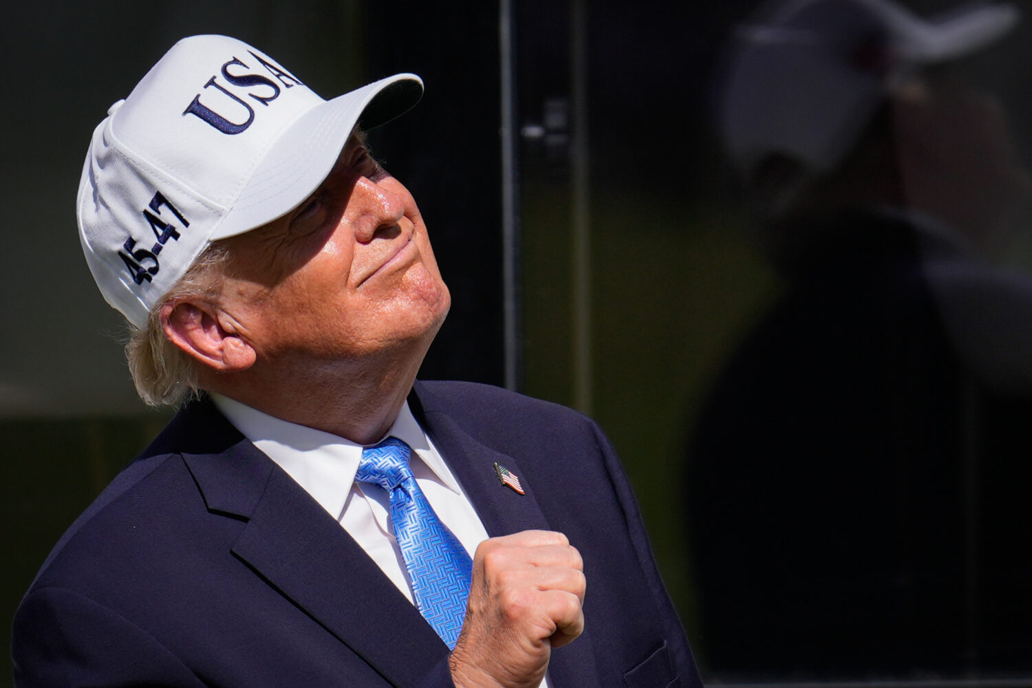 President Donald Trump pumps his fist on the first tee box prior to the Presidents Cup golf tournam...