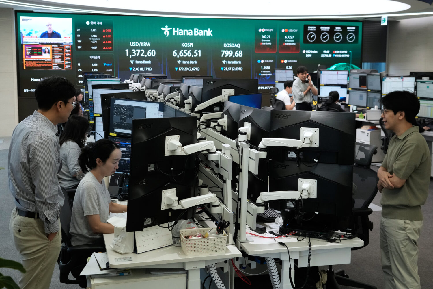 Currency traders work at the foreign exchange dealing room of the Hana Bank headquarters in Seoul, ...
