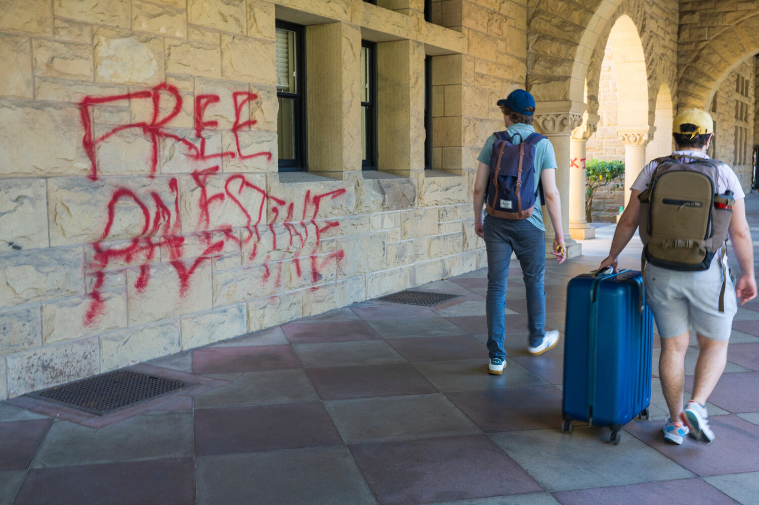 FILE - Students walk by graffiti near President Richard Saller's office at Stanford University in P...